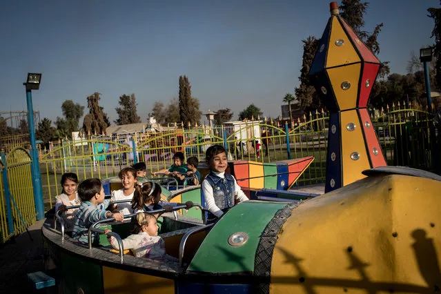 Children enjoy a train ride at the Mosul Amusement Park on November 4, 2017 in Mosul, Iraq. The theme park was shut down under ISIS occupation and the grounds were riddled with mines and IED's, after the liberation staff returned to rebuild the park and rides and reopened on the 5th of October. (Photo by Chris McGrath/Getty Images)