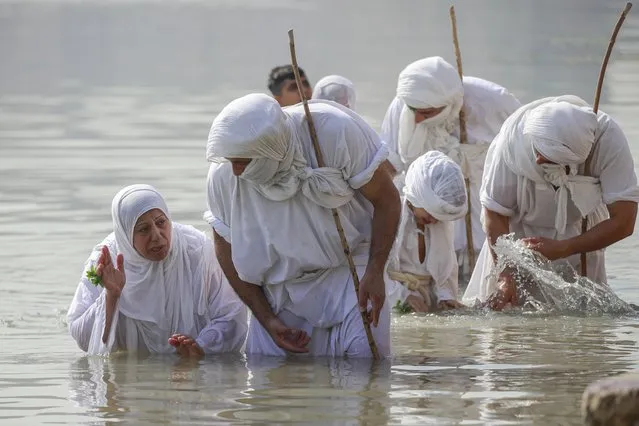 Followers of the ancient Sabean Mandaean community take part in a ritual during the Prosperity Day celebration in the Tigris River in central Baghdad, Iraq, Tuesday, November 1, 2022. Mandaeism follows the teachings of John the Baptist, a saint in both the Christian and Islamic traditions, and its rites revolve around water and prosperity. (Photo by Hadi Mizban/AP Photo)
