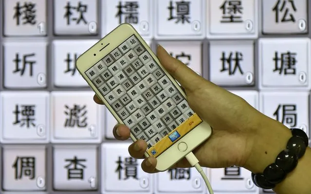 This picture taken on November 2, 2017 shows Steve Tsai, an APP designer of Zihun, displaying his smart phone showing traditional Chinese characters during an interview in Taipei. Concerns in Taiwan are growing over the survival of the traditional Chinese characters used only in Taiwan and Hong Kong as the system of simplified characters created by China in the 1950 s has been adopted by all other ethnic Chinese societies and become the predominant way of writing Chinese. (Photo by Sam Yeh/AFP Photo)