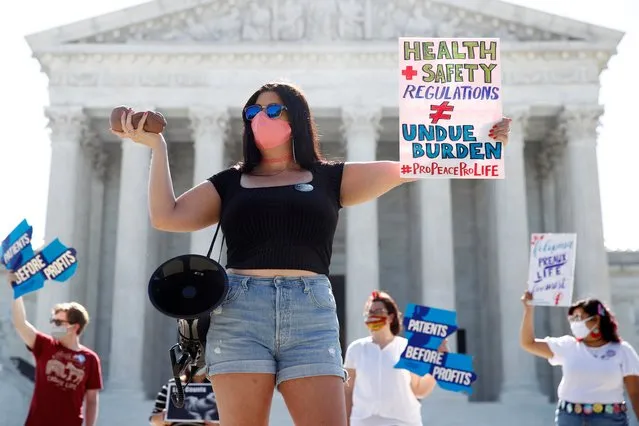 Terrisa Bukovinac, founder of Pro-Life San Francisco, holds a model of a fetus as she and other anti-abortion protesters wait outside the Supreme Court for a decision, Monday, June 29, 2020. The Supreme Court has struck down a Louisiana law regulating abortion clinics, reasserting a commitment to abortion rights over fierce opposition from dissenting conservative justices in the first big abortion case of the Trump era. (Photo by Patrick Semansky/AP Photo)