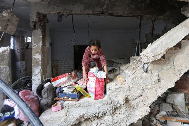A Palestinian girl gathers her belongings at the site of an Israeli strike on a house, in Bureij, in the central Gaza Strip on March 25, 2025. (Photo by Ramadan Abed/Reuters)