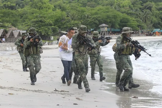 Members of the Philippine Marines rescue a hostage from mock rebels during the Fleet-Marine Amphibious Exercise at the marine headquarter in Ternate, cavite city, south of Manila September 24, 2015. (Photo by Romeo Ranoco/Reuters)
