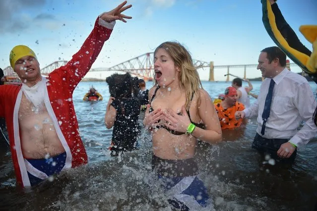 A woman reacts as she joins around a thousand New Year swimmers, many in costume, braved freezing conditions in the River Forth in front of the Forth Rail Bridge during the annual Loony Dook Swim on January 1, 2013 in South Queensferry, Scotland. Thousands of people gathered last night to see in the New Year at Hogmanay celebrations in towns and cities across Scotland.  (Photo by Jeff J. Mitchell)