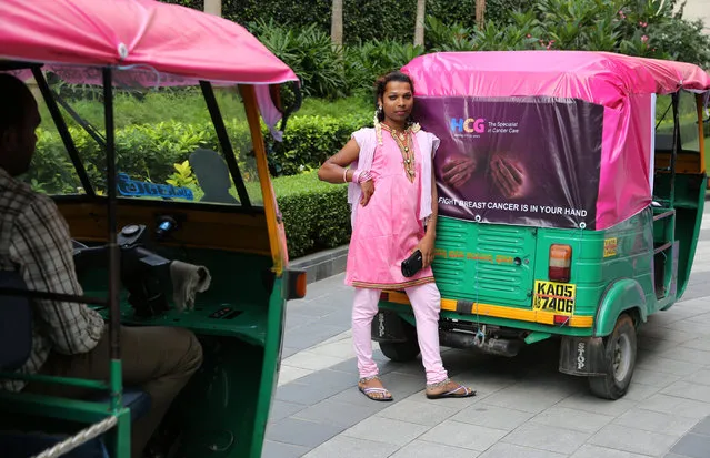 A member of India's transgender community dressed in pink poses next to an autorickshaw during an event for breast cancer awareness in Bangalore, India, Wednesday, October 29, 2014. Breast cancer awareness month is an annual international health campaign observed every October to increase awareness of the disease and its prevention, diagnosis, treatment and cure. According to research one out of eight women are at the risk of developing breast cancer, a release from organizers said. (Photo by Aijaz Rahi/AP Photo)