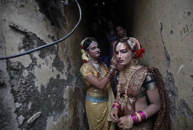 Eunuchs get ready at an alley stairwell before taking part in the Raksha Bandhan festival celebrations in a red light area in Mumbai August 12, 2011. (Photo by Danish Siddiqui/Reuters)