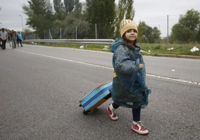 A girl pulls a suitcase as she walks to cross the border from Hungary to Austria in Nickelsdorf, Austria September 11, 2015. (Photo by Leonhard Foeger/Reuters)
