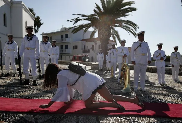 A pilgrim crawls in front of the Navy band outside the Holy Church of Panagia of Tinos, on the Aegean island of Tinos, Greece, on Saturday, August 15, 2020. For nearly 200 years, Greek Orthodox faithful have flocked to Tinos for the August 15 feast day of the Assumption of the Virgin Mary, the most revered religious holiday in the Orthodox calendar after Easter. But this year there was no procession, the ceremony – like so many lives across the globe – upended by the coronavirus pandemic. (Photo by Thanassis Stavrakis/AP Photo)