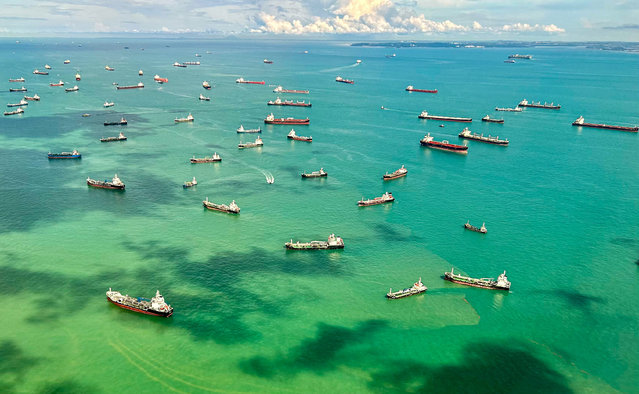 This aerial view taken from a commercial flight shows cargo ships docked along the strait in Singapore on April 7, 2025. (Photo by Mohd Rasfan/AFP Photo)