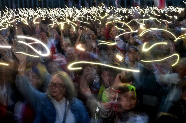 Opposition supporters hold their mobile phones with flashlights on during a rally to protest against disputed presidential elections results in Minsk on August 25, 2020. (Photo by Sergei Gapon/AFP Photo)