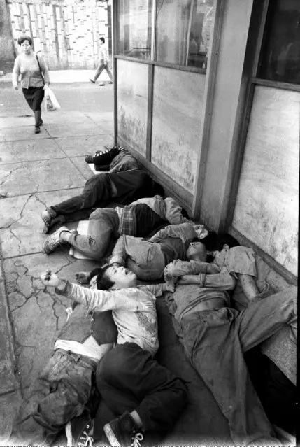 Peruvian street children sleep on a central street of downtown Lima on 15 October, 1992. (Photo by Jaime Razuri/AFP Photo)
