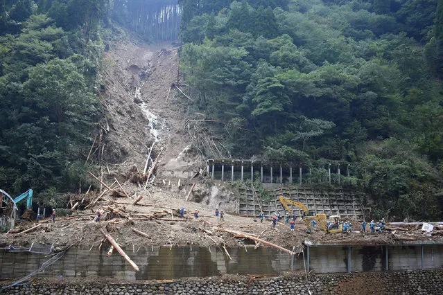 Police (in blue) conduct search and rescue operations at the site of a landslide in the village of Shiiba in Miyazaki Prefecture on September 8, 2020, after Typhoon Haishen grazed the southern Japanese island of Kyushu the day before. The powerful typhoon went on to lash South Korea on September 7 after smashing into southern Japan with record winds and heavy rains that left up to eight people dead or missing. (Photo by JIJI Press/AFP Photo)