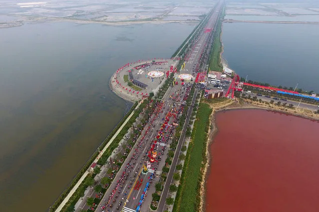 A salt lake which is separated by a road, shows parts of it in different colours due to algae, in Yuncheng, Shanxi Province, China, September 25, 2016. (Photo by Wei Liang/Reuters)