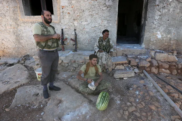 Rebel fighters rest with their weapons near a watermelon in northern Aleppo countryside, Syria September 30, 2016. (Photo by Khalil Ashawi/Reuters)