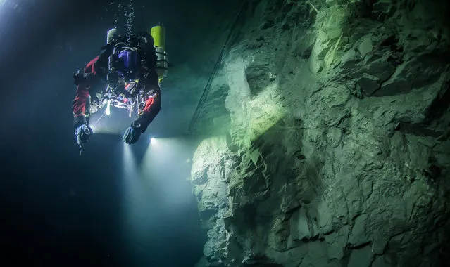 In this underwater photo taken August 21, 2015, in the flooded Hranicka Abyss, Czech Republic, Polish explorer Krzysztof Starnawski is seen examining the limestone crevasse and preparing for a 2016 expedition to measure it depths. On September 27, 2016 Starnawski and his Polish-Czech team discovered that the cave goes 404 meters (1,325 feet) down, making it the world's deepest known flooded abyss. (Photo by Krzysztof Starnawski of the Krzysztof Starnawski Expedition via AP Photo)