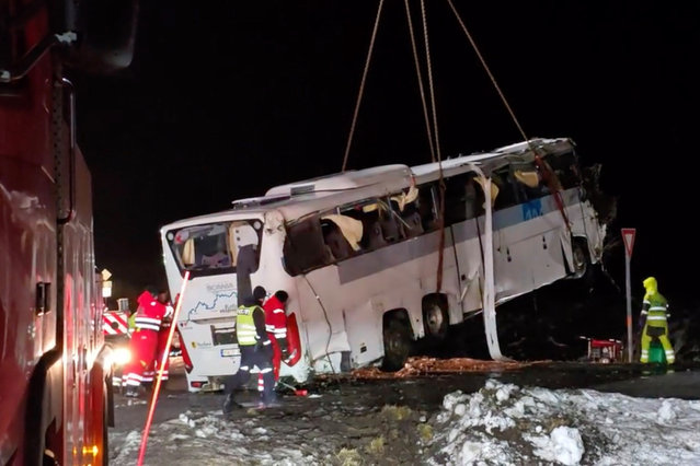 A crane truck lifts a bus driven off the road in Hadsel, Norway, 27 December 2024. Three people have died and four are seriously injured after a bus drove off the road on the E10 in Hadsel, Nordland. 58 people were involved, and the bus is partially underwater. (Photo by Jens Andre M. Birkeland/EPA/EFE)