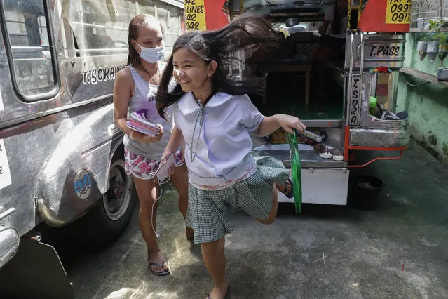 Student Bhea Joy Roxas, right, smiles after finishing her first online class using a nearby store's wifi connection in Quezon city, Philippines on Monday, October 5, 2020. (Photo by Aaron Favila/AP Photo)