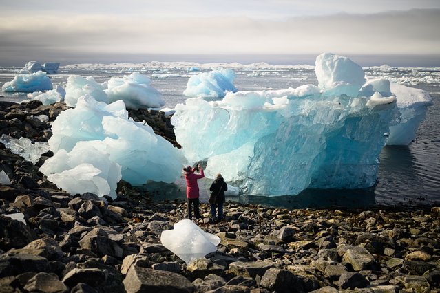 Tourists explore the large chunks of ice washed up on the beach on March 30, 2025 in Nuuk, Greenland. The Arctic territory is experiencing an unexpected surge in tourism, fuelled by both the opening of a new international airport in the capital, Nuuk, and US President Donald Trump’s recent controversial announcement that he plans to annex the territory. Recent figures show a 14% rise in the number of visitors in January, with tourism operators confirming an increase in bookings since the airport’s opening. Before the opening of Nuuk International Airport, there were no direct international flights to Greenland’s capital, home to fewer than 20,000 people. (Photo by Leon Neal/Getty Images)