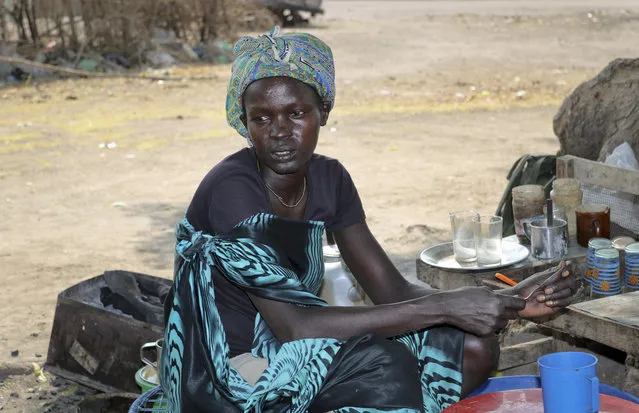 In this photo taken Thursday, January 18, 2018, Nyakum Well, 27, who said she was separated from her two young children five days before when government troops attacked her town of Pieri, pours tea at her shop in the market in Akobo town, one of the last rebel-held strongholds in South Sudan. South Sudan's opposition is threatening to resort to “guerrilla warfare” if peace talks in Ethiopia fail in the coming days as government forces advance on remaining rebel strongholds in the fifth year of civil war. (Photo by Sam Mednick/AP Photo)