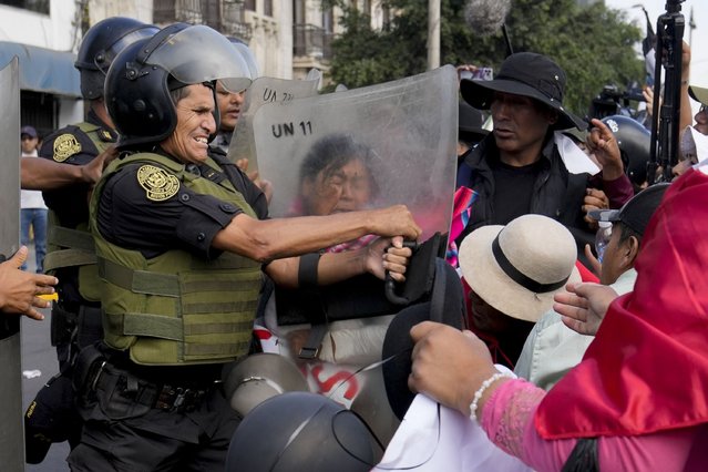Anti-government protesters try to get past riot police blocking their path to the Palace of Justice during a demonstration marking International Workers' Day, in Lima, Peru, May 1, 2024. (Photo by Martin Mejia/AP Photo)