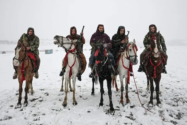 Taliban fighters pose for pictures while riding rental horses during a snowfall at the Qargha lake in Kabul on January 3, 2022. (Photo by Mohd Rasfan/AFP Photo)