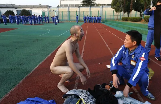 A newly-admitted recovering drug addict (front L) opens his mouth after taking off his clothes for a routine check for smuggled items, at Shiliping compulsory drug rehabilitation centre in Longyou county, Zhejiang province December 4, 2014. Established in 2008, the centre is one of the biggest in China in terms of numbers of recovering addicts and facilities. Recovering drug addicts in the centre undergo treatment with a strict regime in physical exercises, psychological therapies and medication, according to local media. (Photo by William Hong/Reuters)