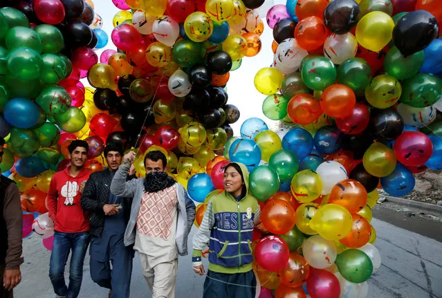 Men hold balloons for sale during Afghan spring and new year celebrations in Kabul, Afghanistan March 21, 2018. (Photo by Mohammad Ismail/Reuters)