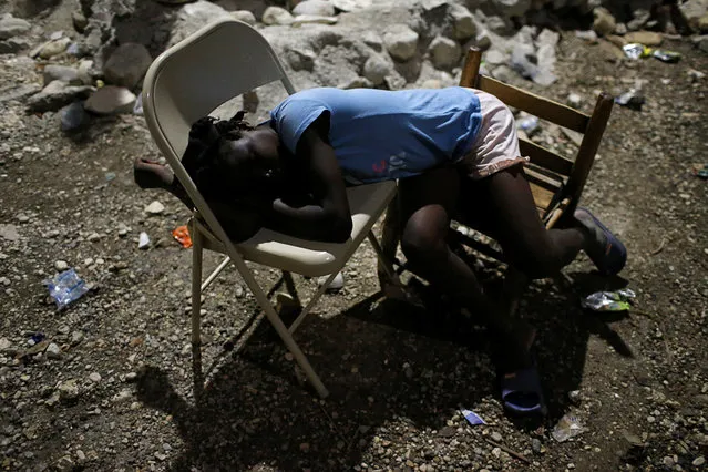 A girl sleeps on chairs in a partially destroyed school used as a shelter after Hurricane Matthew hit Jeremie, Haiti, October 12, 2016. (Photo by Carlos Garcia Rawlins/Reuters)