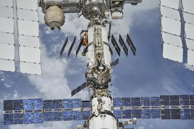 In this photo provided by NASA/Roscosmos, the International Space Station floats above the Earth as seen from a Soyuz spacecraft after undocking on October 4, 2018. NASA astronauts Andrew Feustel and Ricky Arnold and Roscosmos cosmonaut Oleg Artemyev executed a fly around of the orbiting laboratory to take pictures of the station before returning home after spending 197 days in space. Twenty years after the first crew arrived, the space station has hosted 241 residents. (Photo by NASA/Roscosmos via AP Photo)