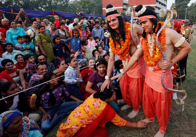 A woman seeks blessings from artists dressed as Hindu lord Rama and his brother Laxman during Vijaya Dashmi or Dussehra festival celebrations in Chandigarh, India October 11, 2016. (Photo by Ajay Verma/Reuters)