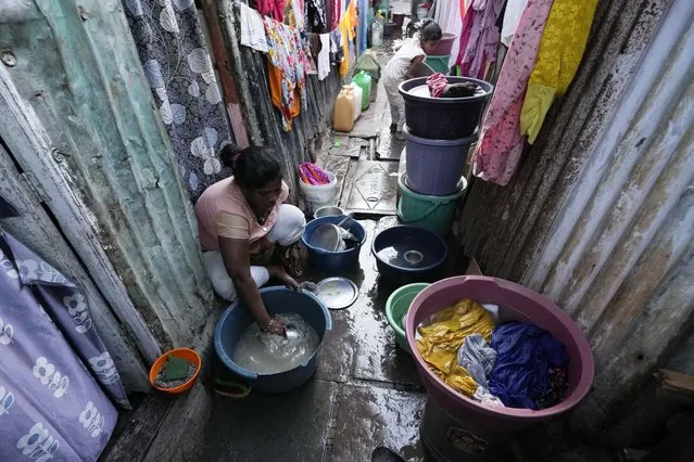 A woman washes utensils outside her house in a slum area on the eve of World Water Day in Mumbai, India, March 21, 2023. (Photo by Rajanish Kakade/AP Photo)