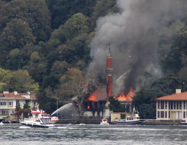 A fire engulfs Vanikoy Mosque, a historic wooden mosque, in Istanbul, Sunday, November 15, 2020. The Vanikoy Mosque, built in the 17th century during the reign of Ottoman Sultan IV Mehmed, is located on the Asian side of Istanbul along the Bosporus Strait. Turkish firefighters were trying to put out the blaze from both land and sea. (Photo by DHA via AP Photo)