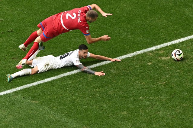 Serbia's defender #02 Strahinja Pavlovic (up) fights for the ball with Slovenia's defender #20 Petar Stojanovic  during the UEFA Euro 2024 Group C football match between Slovenia and Serbia at the Munich Football Arena in Munich on June 20, 2024. (Photo by Thomas Kienzle/AFP Photo)