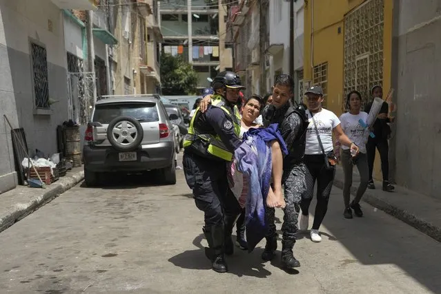 Police carry a woman to a hospital after she gave birth to a baby boy inside her apartment in Caracas, Venezuela, Wednesday, March 8, 2023. Nurses who were protesting nearby for a better salaries on International Woman's Day helped deliver the baby and cut the umbilical chord. (Photo by Ariana Cubillos/AP Photo)