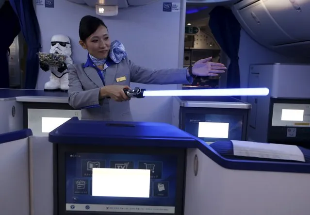 A stewardess holding a lightsabre explains the features of the business class section during a tour of the Star Wars themed All Nippon Airways ANA R2D2 Boeing 787 Dreamliner aircraft at Singapore's Changi Airport November 12, 2015. (Photo by Edgar Su/Reuters)