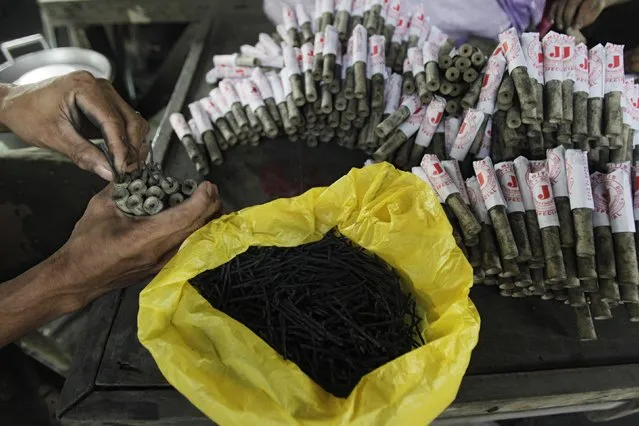 A worker makes firecrackers at a makeshift factory in Bocaue town, Bulacan province, north of Manila December 27, 2014. (Photo by Romeo Ranoco/Reuters)