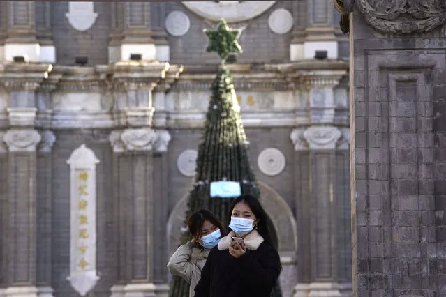 Visitors pose for a selfie outside the Wangfujing Church in Beijing on Friday, December 25, 2020. Official churches in the Chinese capital abruptly cancelled mass on Christmas day in a last-minute move owing to the pandemic. The capital city is on high alert after new confirmed COVID-19 cases were reported last week and new asymptomatic cases reported Christmas day. (Photo by Ng Han Guan/AP Photo)