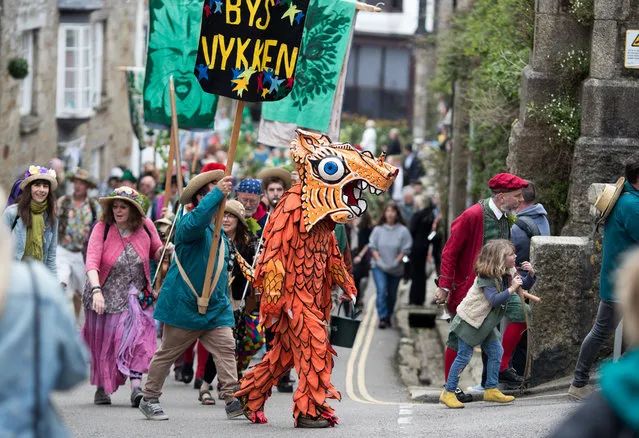 Performers take part in the Hal-an-Tow dance as they celebrate Helston Flora Day on May 8, 2018 in Cornwall, England. The annual Flora Dance, also known as the Furry Dance, is one of the UK's oldest customs still practised today and is said to be a celebration of the passing of Winter and the arrival of Spring. A series of dances as well as a Hal-an-Tow pageant take place throughout the day, beginning at 7am all over the Cornish town and even in and out of private houses and shops. However the highlight is the midday dance which was traditionally the dance of the gentry in the town and is why men still wear top hats and tails while the women dance in their finest dresses.(Photo by Matt Cardy/Getty Images)