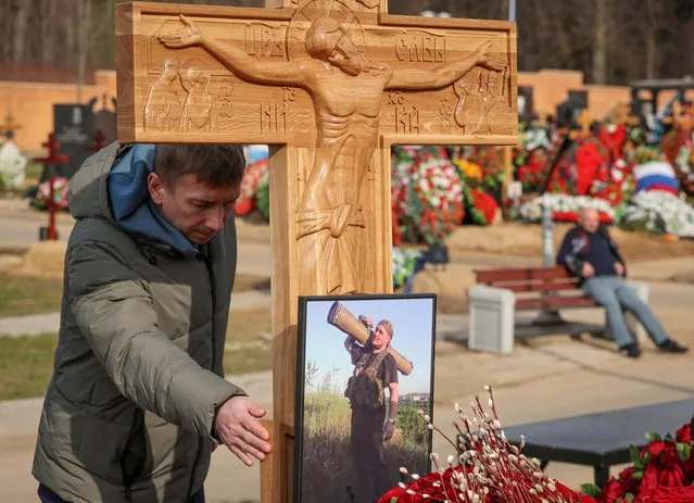 A mourner visits the grave of Russian military blogger Maxim Fomin, widely known by the name of Vladlen Tatarsky, who was recently killed in a bomb attack in a St Petersburg cafe, in Moscow, Russia on April 8, 2023. (Photo by Yulia Morozova/Reuters)