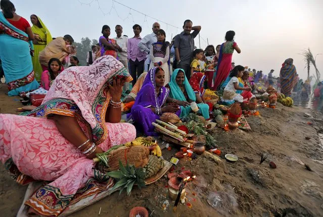 Hindu women prepare to worship the Sun god Surya on the banks of river Sabarmati during the Hindu religious festival of Chatt Puja in Ahmedabad, India, November 17, 2015. (Photo by Amit Dave/Reuters)