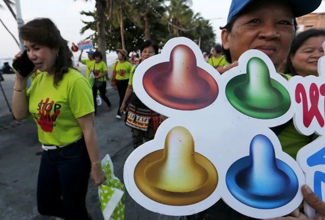 An activist holds a banner as others march through Pattaya resort town to raise awareness on the World Aids Day in Pattaya, east of Bangkok, Thailand December 1, 2015. (Photo by Chaiwat Subprasom/Reuters)