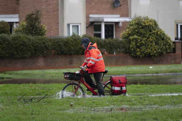 A postman riding through floodwater in West Derby in Liverpool after heavy rain in the region, Liverpool, United Kingdom on December 8, 2020. (Photo by Jon Super/Rex Features/Shutterstock)