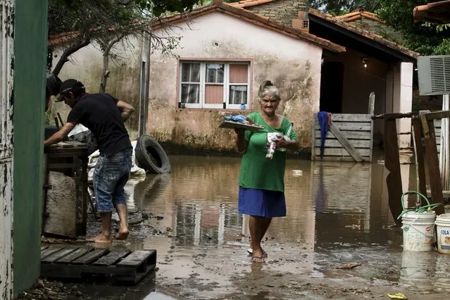 A woman is pictured near a house partially submerged in flood waters in Asuncion, December 20, 2015. (Photo by Jorge Adorno/Reuters)