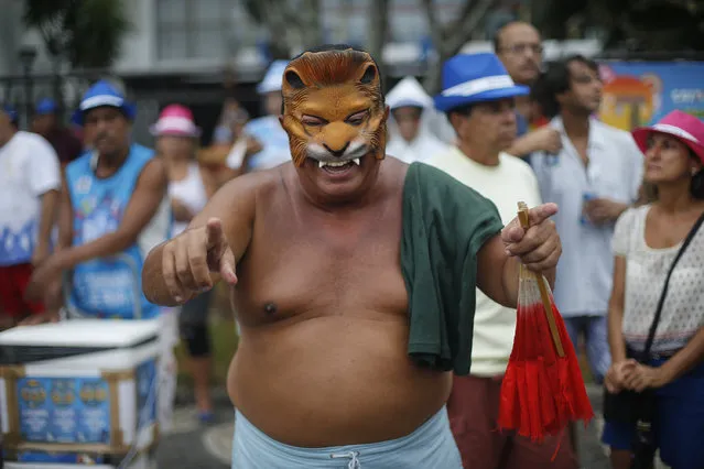 A man wears a mask during the Banda de Ipanema carnival parade in Rio de Janeiro, Brazil, Saturday, January 31, 2015. (Photo by Silvia Izquierdo/AP Photo)