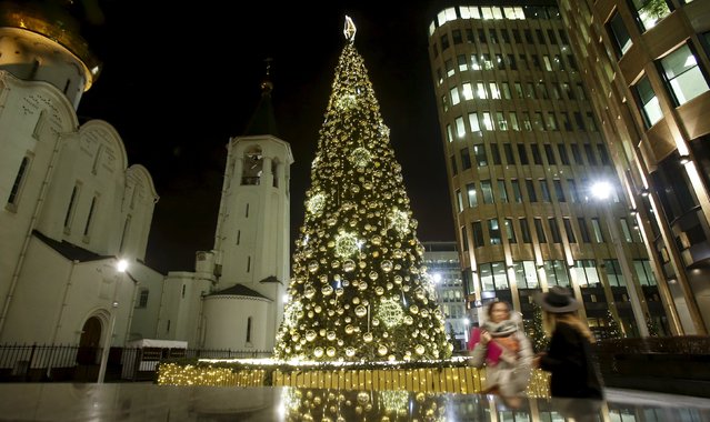 Young women walk past a Christmas tree in central Moscow, Russia, December 14, 2015. (Photo by Maxim Shemetov/Reuters)