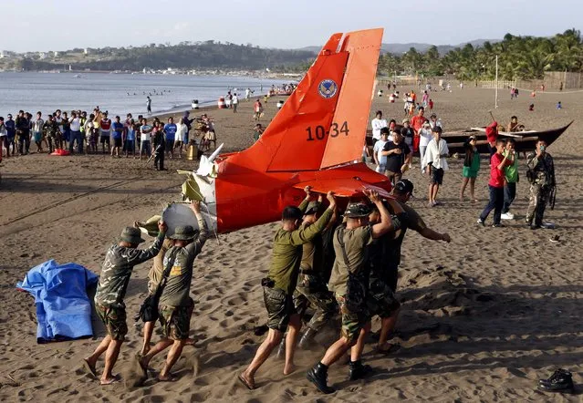 Soldiers carry the tail of an ill-fated Philippine Air Force Italian made light aircraft SIAI-Marchetti SF260 that crashed in the sea off the coast of Nasugbo, Batangas south of Manila, February 1, 2015. Philippine Air Force spokesman Lt. Col. Enrico Canaya said the trainer plane SF-260FH went down, killing its two pilots, while on a three aircraft formation training mission near the shoreline in the coastal town of Nasugbu, Batangas. (Photo by Erik De Castro/Reuters)