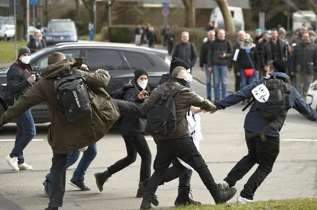 Participants scuffle at a rally under the slogan “Free citizens Kassel – basic rights and democracy” in Kassel, Germany, Saturday, March 20, 2021. According to police, several thousand people were on the move in the city center and disregarded the instructions of the authorities during the unregistered demonstration against Corona measures. (Photo by Swen Pfoertner/dpa via AP Photo)