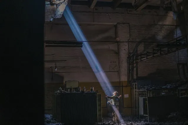 In this photo provided by Azov Special Forces Regiment of the Ukrainian National Guard Press Office, A Ukrainian soldier inside the ruined Azovstal steel plant stands under a sunlight ray in his shelter in Mariupol, Ukraine, May 7, 2022. For nearly three months, Azovstal’s garrison clung on, refusing to be winkled out from the tunnels and bunkers under the ruins of the labyrinthine mill. A Ukrainian soldier-photographer documented the events and sent them to the world. Now he is a prisoner of the Russians. His photos are his legacy. (Photo by Dmytro Kozatski/Azov Special Forces Regiment of the Ukrainian National Guard Press Office via AP Photo)