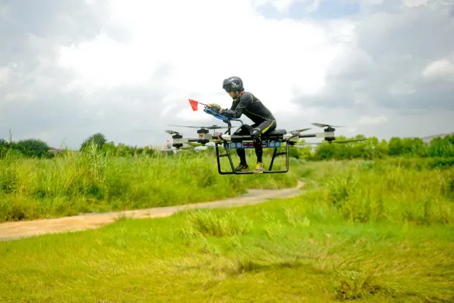 40 year old Chinese man Zhao Deli, who was dressed in all-black protective suit, took part in the 1,564th test flight for his flying motorcycle in Tangxia town, Dongguan city, south China's Guangdong province. With the eight propellers stirring the air and the motor roaring, his flying vehicle soared high into the air. Homemade drone bike takes flight, Tangxia town, Dongguan city, Guangdong province, China on July 23, 2018. Zhao introduced that the “flying motorcycle” can reach a speed of 70 kilometers per hour with a battery life of 30 minutes, a pay load of 50 to 100 kilograms, and a maximum takeoff weight of 256 kilograms, which make the “flying motorcycle” in the leading position currently on the market. (Photo by Imaginechina/Rex Features/Shutterstock)