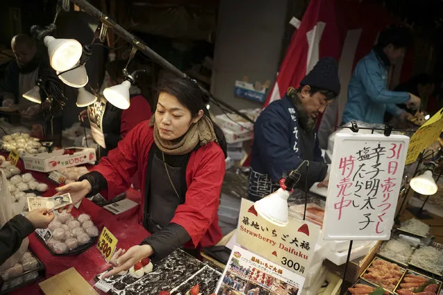 Venders sell ingredients for “osechi” or Japanese traditional New Year dishes, near Tsukiji fish market in Tokyo, Thursday, December 31, 2015. (Photo by Eugene Hoshiko/AP Photo)