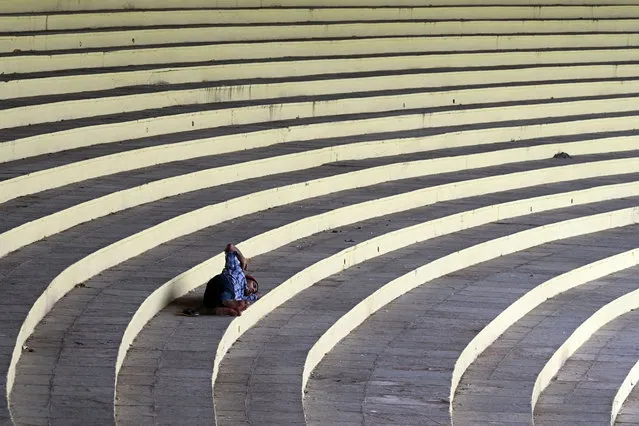 A man takes a nap inside the Lal Bahadur Stadium in Hyderabad on August 7, 2023. (Photo by Noah Seelam/AFP Photo)